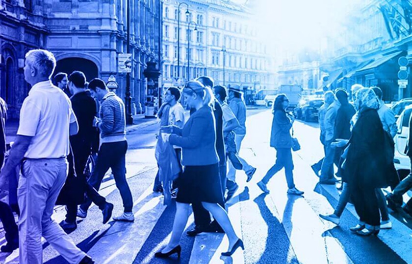 People walk across a zebra crossing to the left and right