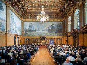 Blick über das zahlreiche Publikum auf die Bühne des Festsaals im Hamburger Rathaus