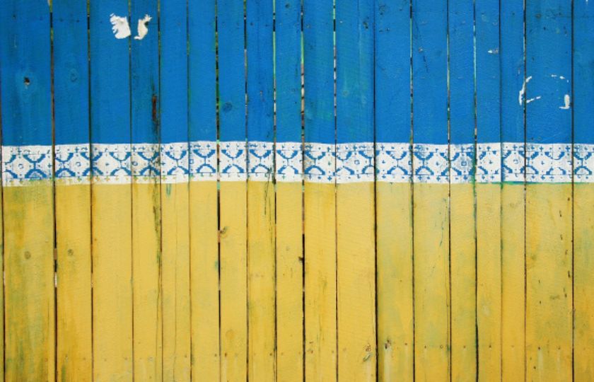 Eine Holzwand, gestrichen in den Farben blau und gelb.